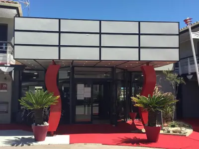 a building with two potted plants in front of it at Hotel Le Phoebus Garden & Spa in Gruissan