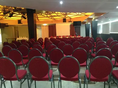 an empty room with red chairs and a screen at Hotel Le Phoebus Garden & Spa in Gruissan