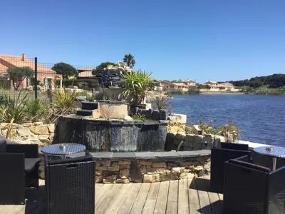 a water fountain in front of a body of water at Hotel Le Phoebus Garden & Spa in Gruissan