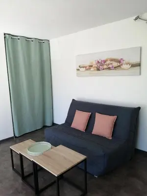 a living room with a blue couch and a table at la fenass in Noailhac