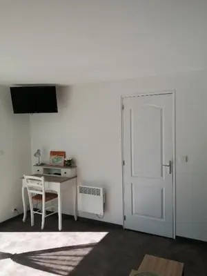 a white room with a white door and a desk at la fenass in Noailhac