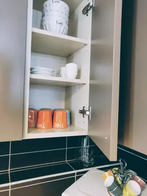a bathroom with a cupboard with cups and plates at Appartement L'Oliveraie - La Cité plein les yeux in Carcassonne