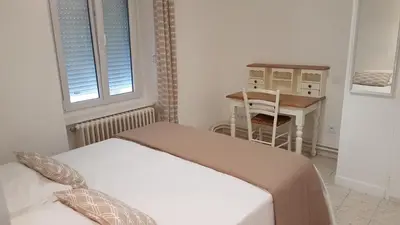 a bedroom with a bed and a desk and a table at La Bulle familles Clim, wifi, airport shuttle,tout à pied in Carcassonne