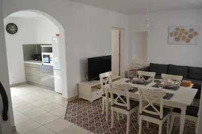 a living room with a table and chairs and a couch at La Bulle familles Clim, wifi, airport shuttle,tout à pied in Carcassonne