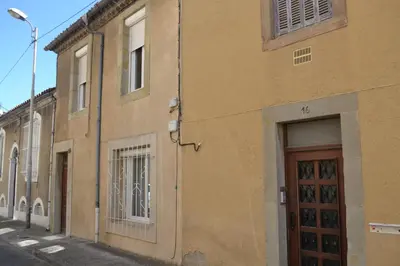 a brown building with a door on a street at La Bulle familles Clim, wifi, airport shuttle,tout à pied in Carcassonne