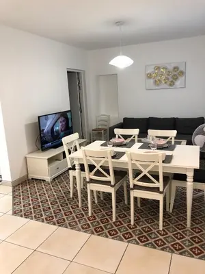 a living room with a table and chairs and a couch at La Bulle familles Clim, wifi, airport shuttle,tout à pied in Carcassonne