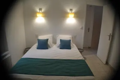 a bedroom with a bed with two blue pillows at La Bulle familles Clim, wifi, airport shuttle,tout à pied in Carcassonne
