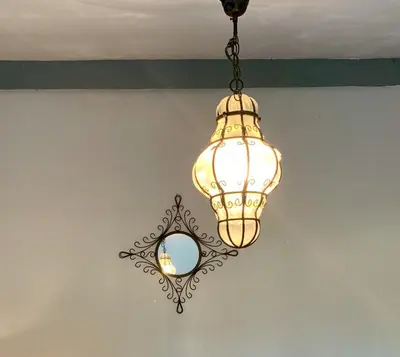 a chandelier hanging from a ceiling with a mirror at La Meyssonnié in Damiatte