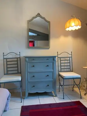 a bedroom with a blue dresser and two chairs at La Meyssonnié in Damiatte