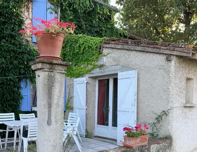 a building with a pot of flowers on a pole at La Meyssonnié in Damiatte