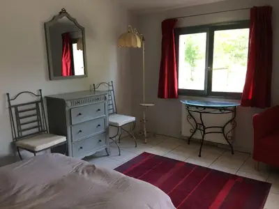 a bedroom with a bed and a desk and a mirror at La Meyssonnié in Damiatte
