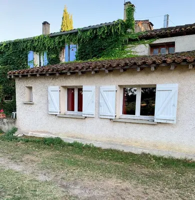 an old house with white windows and ivy at La Meyssonnié in Damiatte