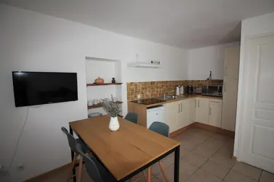 a kitchen with a table and chairs and a window at Le Jardin du Somail in Le Somail