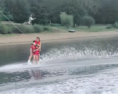 a woman and a child water skiing on a lake at Maison accueillante à La Salvetat-sur-Agout avec terrasse in La Salvetat