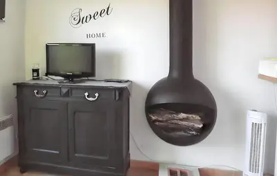 a room with a fireplace and a tv and aburning at Maison accueillante à La Salvetat-sur-Agout avec terrasse in La Salvetat