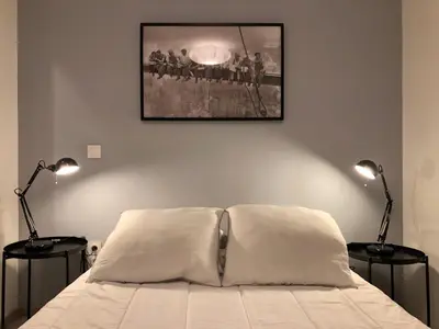 a bedroom with a bed and a mirror and a lamp at La Bastide 1 à 6 personnes en centre ville in Carcassonne