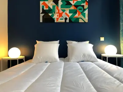 a bed with white sheets and pillows in a bedroom at City'IN Appart in Carcassonne