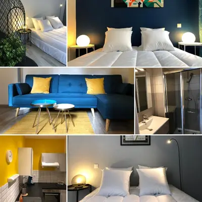 a room with a blue couch and a bed at City'IN Appart in Carcassonne