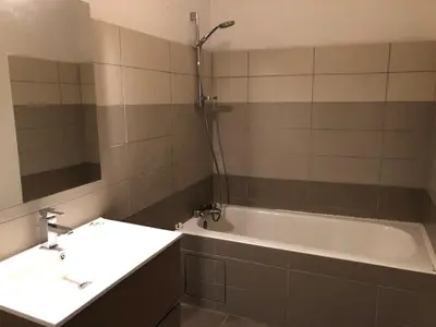 a bathroom with a tub and a sink and a mirror at City'IN Appart in Carcassonne