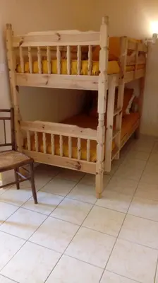 a couple of bunk beds in a room with a chair at Au Coeur de Rennes Chambres d'hôtes in Rennes-les-Bains