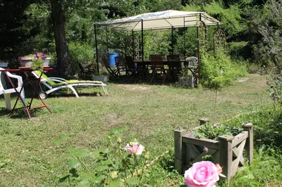 a garden with a picnic table and a gazebo at Au Coeur de Rennes Chambres d'hôtes in Rennes-les-Bains