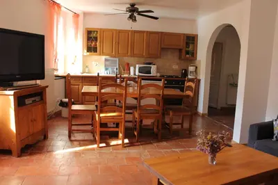 a kitchen and dining room with a table and chairs at Au Coeur de Rennes Gîte in Rennes-les-Bains