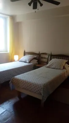 a bedroom with two beds and a ceiling fan at Au Coeur de Rennes Gîte in Rennes-les-Bains