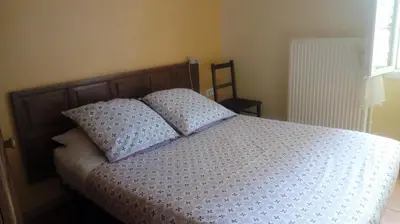 a bed with two pillows on it in a bedroom at Au Coeur de Rennes Gîte in Rennes-les-Bains