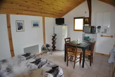 a kitchen and dining room with a table and a refrigerator at Les Divines Cascades in Roquefort-les-Cascades