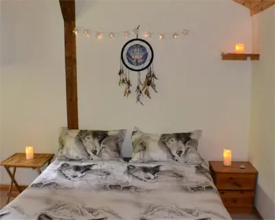 a bedroom with a bed with wolf pillows and candles at Les Divines Cascades in Roquefort-les-Cascades