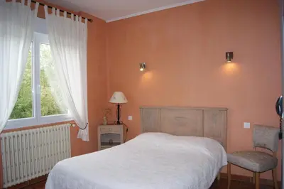 a bedroom with a white bed and a window at Hôtel La Renaissance in Revel