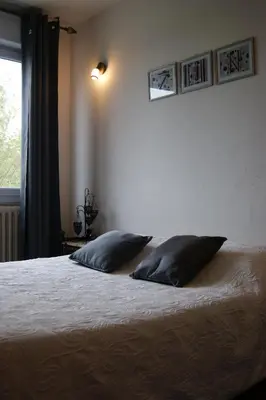a bedroom with two beds and a lamp at Hôtel La Renaissance in Revel