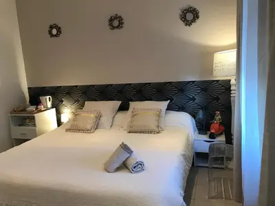 a bedroom with a large white bed with two pillows at Le Marty in Narbonne