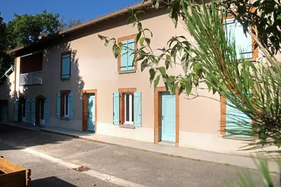 a white building with blue doors and windows at LA BOURDETTE in Saverdun