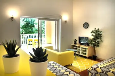 a living room with a yellow couch and potted plants at LA BOURDETTE in Saverdun