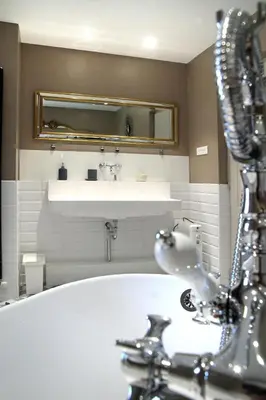 a bathroom with a tub and a sink at LA BOURDETTE in Saverdun