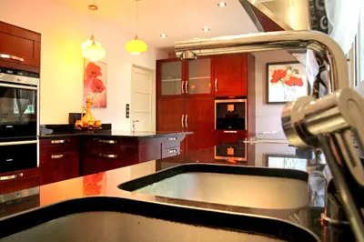a kitchen with wooden cabinets and a sink at LA BOURDETTE in Saverdun