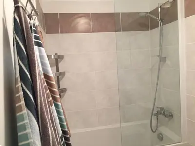 a bathroom with a shower with a glass door at Modern Boulangerie, large 6 bedroom village house in Quillan