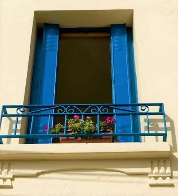 a blue balcony with flowers on a window at Modern Boulangerie, large 6 bedroom village house in Quillan