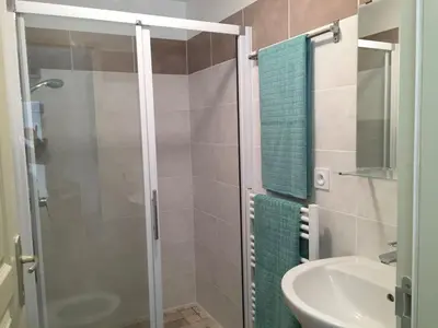 a bathroom with a glass shower and a sink at Modern Boulangerie, large 6 bedroom village house in Quillan
