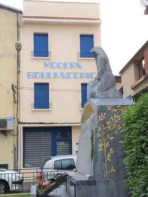 a statue of a woman in front of a building at Modern Boulangerie, large 6 bedroom village house in Quillan