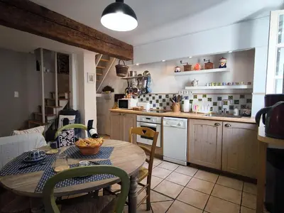 a kitchen with a table and a table and chairs at Maison des Remparts nichée sous la Cité in Carcassonne