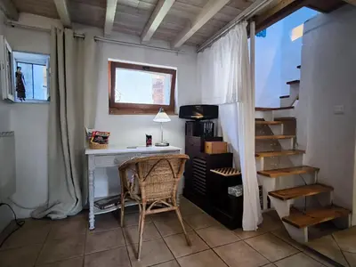 a room with a desk and stairs with a window at Maison des Remparts nichée sous la Cité in Carcassonne