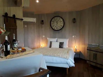 a bedroom with a bed and a clock on the wall at Cabanes Trésors de Campagne,spas privatifs in Villarzel-du-Razès