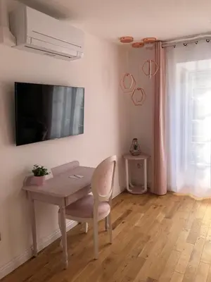 a dining room with a table and a television on the wall at Le Cœur de la Bastide - Adult only in Carcassonne