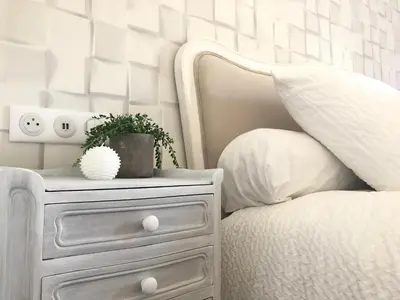 a bedroom with a white bed and a nightstand with a plant at Le Cœur de la Bastide - Adult only in Carcassonne