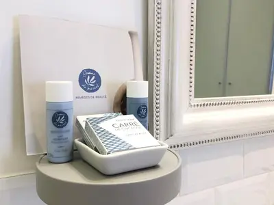 a bathroom with a mirror and some products on a table at Le Cœur de la Bastide - Adult only in Carcassonne