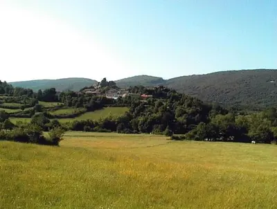 a field of grass with a house on a hill at Le Chateau in Camps-sur-lʼAgly