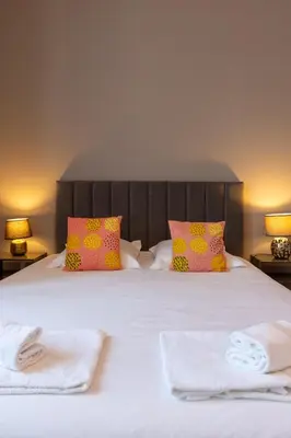 a bedroom with a bed with two towels and two lamps at Abitarela - Maison d'Hôtes - B&B in Sigean