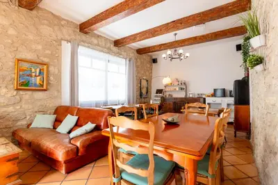 a living room with a table and a couch at Abitarela - Maison d'Hôtes - B&B in Sigean